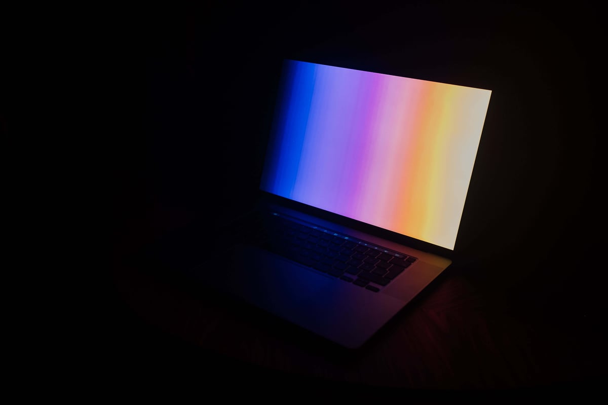 A glowing laptop in a dark setting, showcasing the latest in new and used electronics for sale on our website.